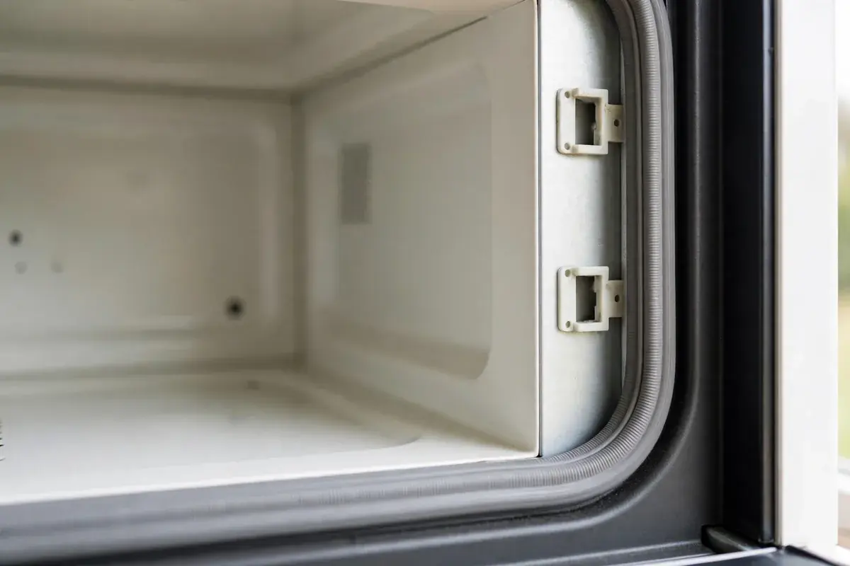 Over the range microwave door latch hooks and the interlock opening on the cavity frame
