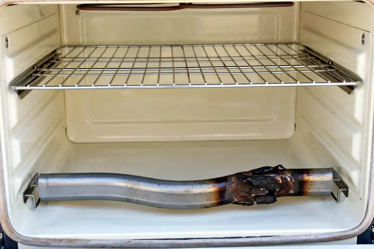 Electric oven bake element with a blistered section inside a clean oven cavity